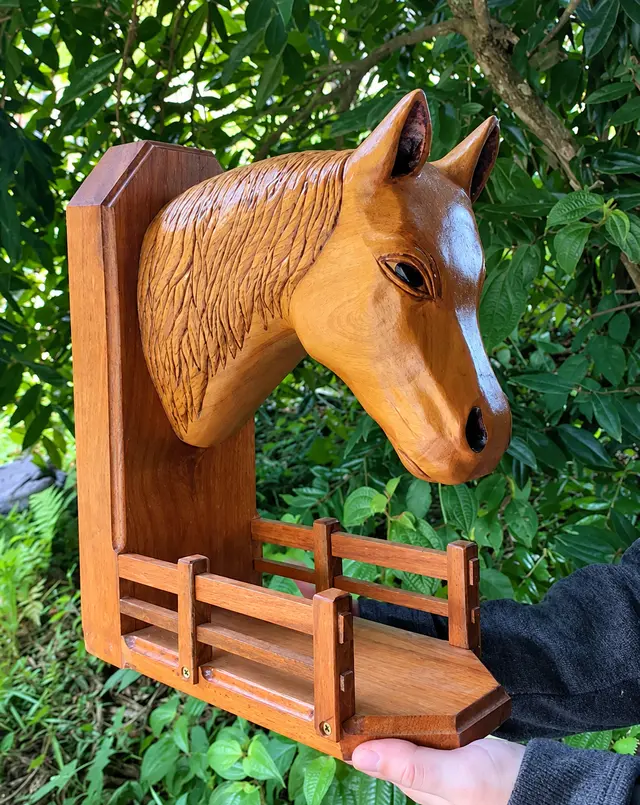 Escultura de cabeça de cavalo entalhada em madeira, fixada em placa com prateleira